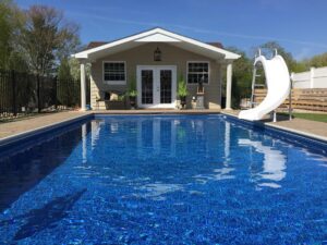 backyard pool with slide in the middle of the day