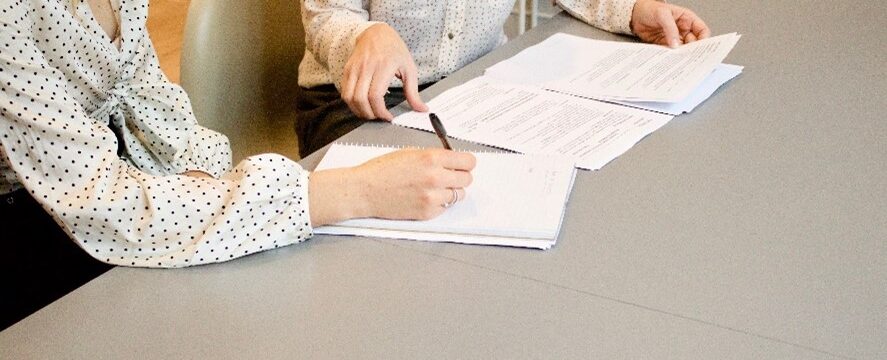 two people having a meeting looking through paperwork